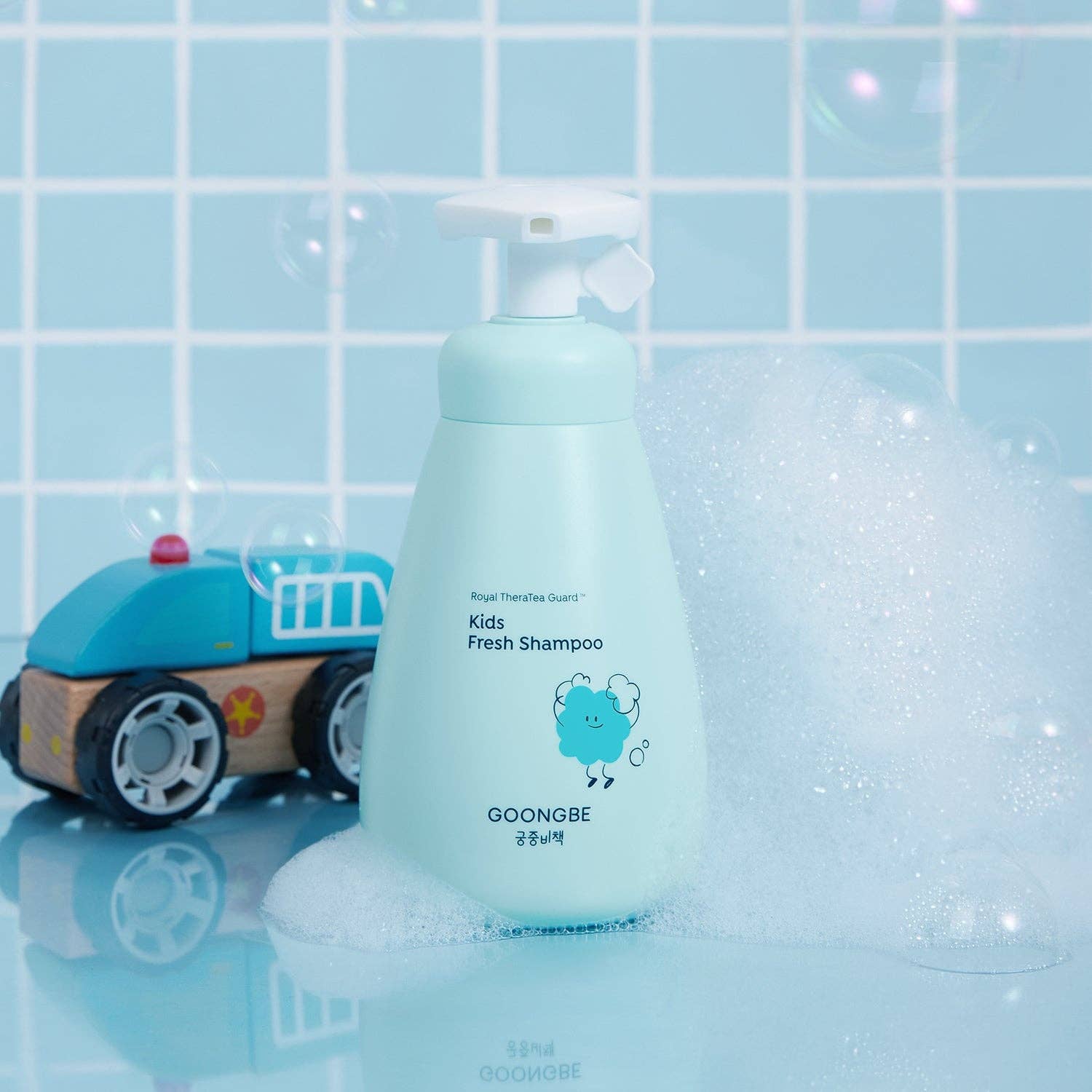 Bottle of GOONGBE Kids Fresh Shampoo with a toy car on a tiled bathroom floor.